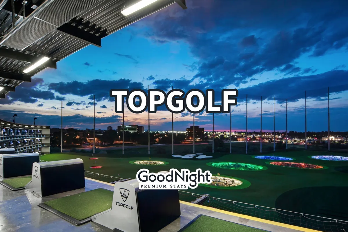 A vibrant exterior shot of Topgolf with multiple golfing bays, colorful target greens, and the Nashville skyline in the background. The scene is active and energetic, welcoming groups and families to enjoy recreational time together.