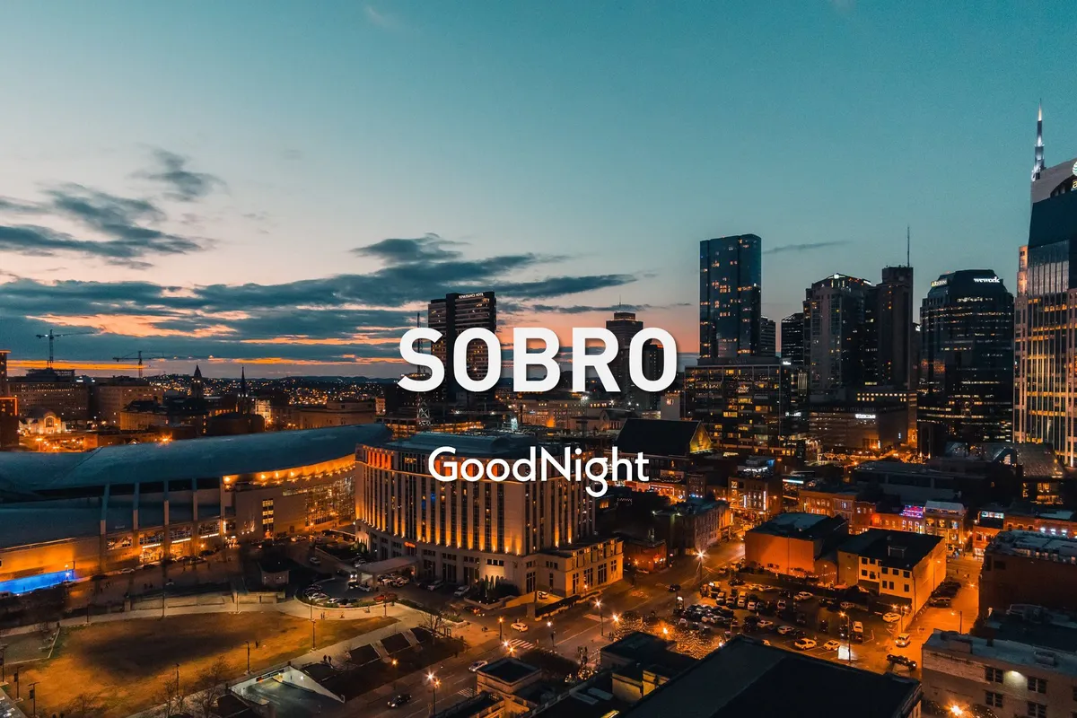 An elevated cityscape view with the Nashville skyline illuminated at sunset, highlighting a transition from daytime exploration to the pulse of the city at night. The image hints at rooftop dining, nightlife adventures, and the excitement of nearby Music Row and Broadway.